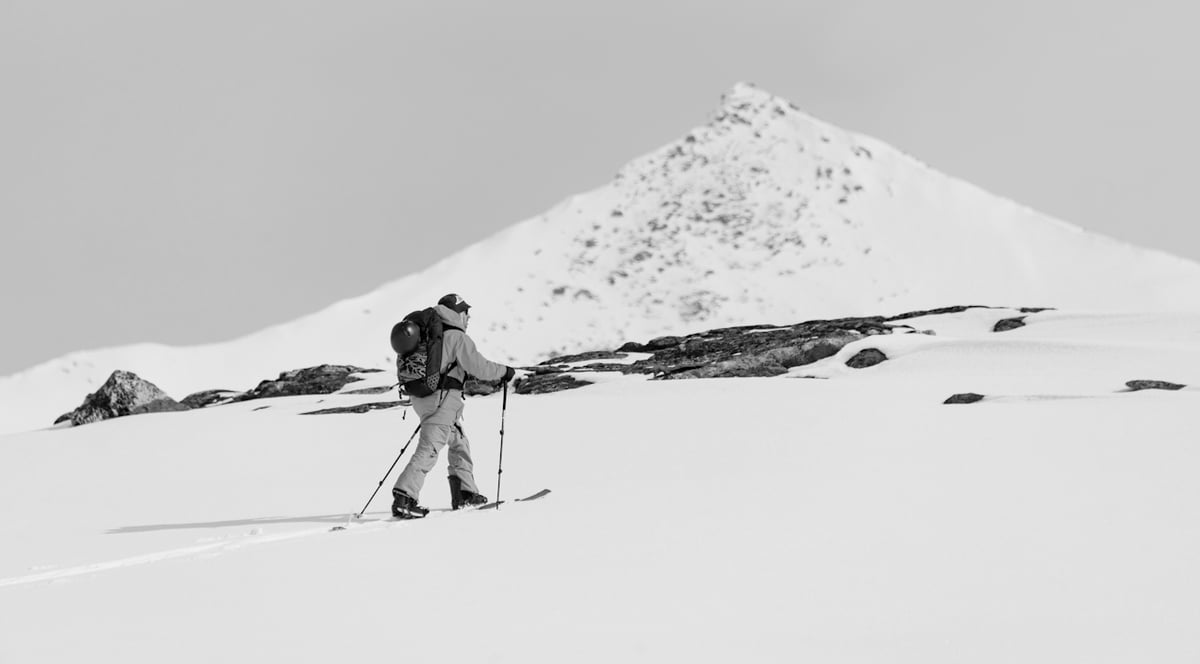 En mann som går på fjellski med et fjell i bakgrunnen