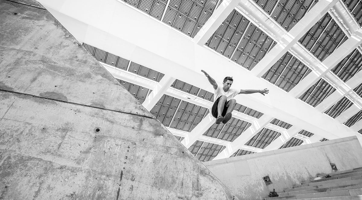 Man som hoppar från en mur