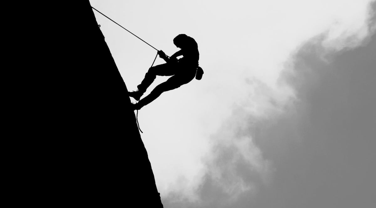 En bergsklättrare som rappellerar