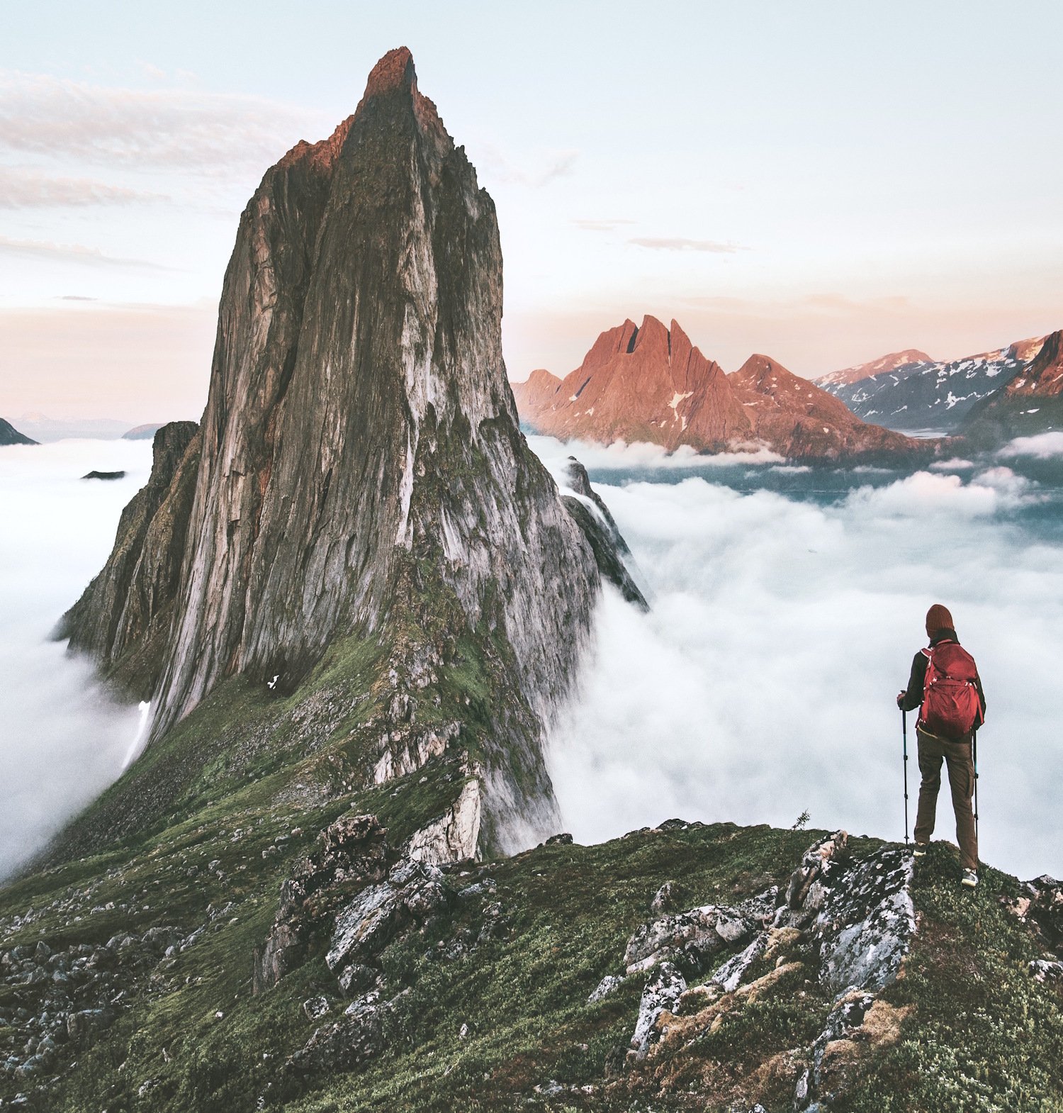 Mann som står og ser mot fjellet Segla med tett skylag rundt