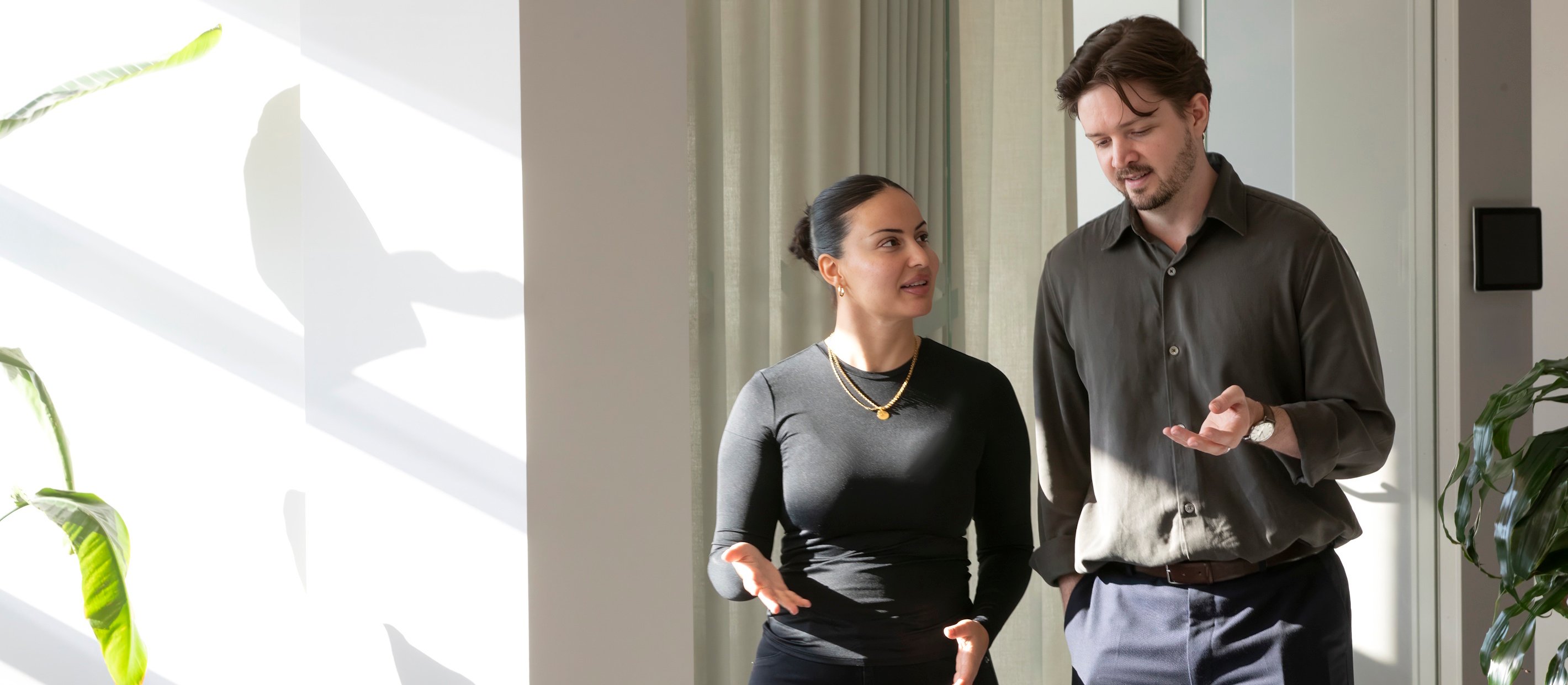 En kvinna och en man som går och pratar på kontoret