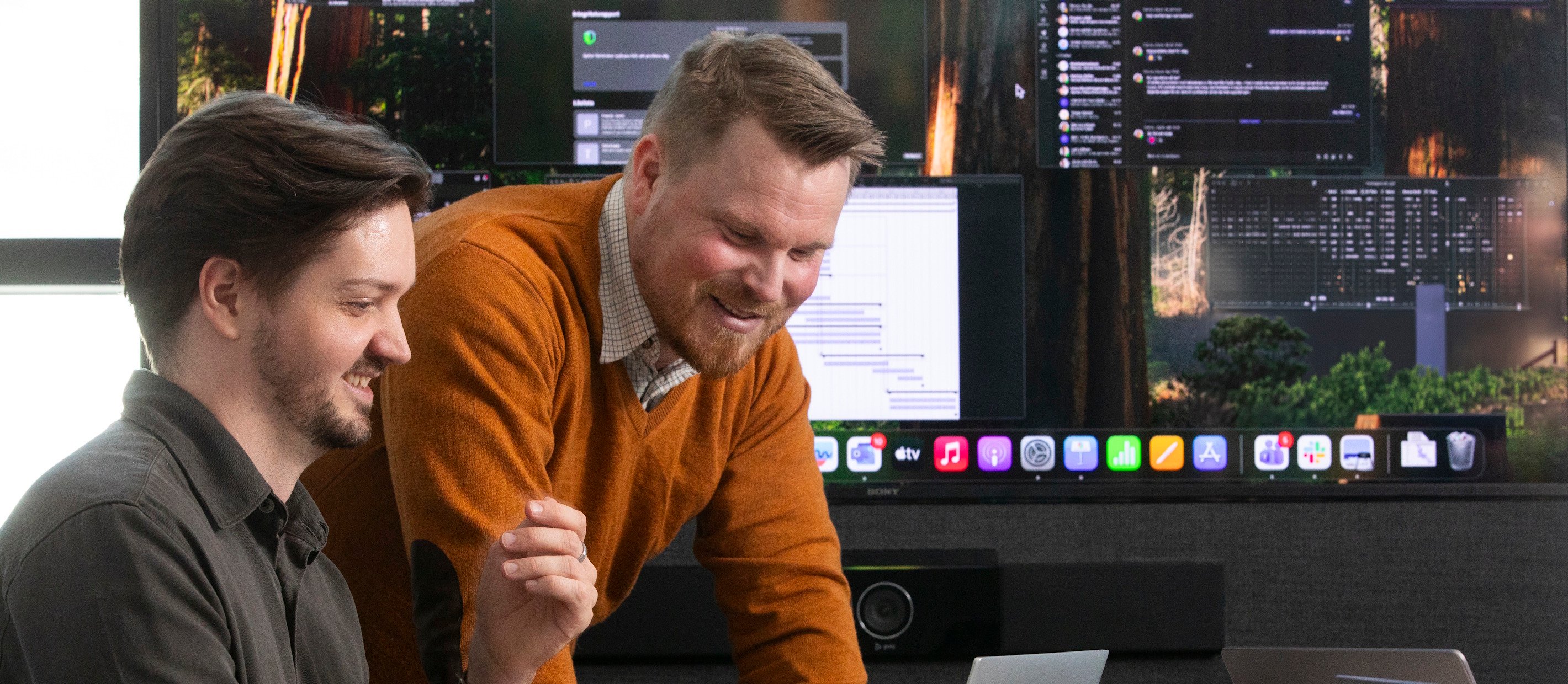 Två män som tittar på en dator och arbetar tillsammans