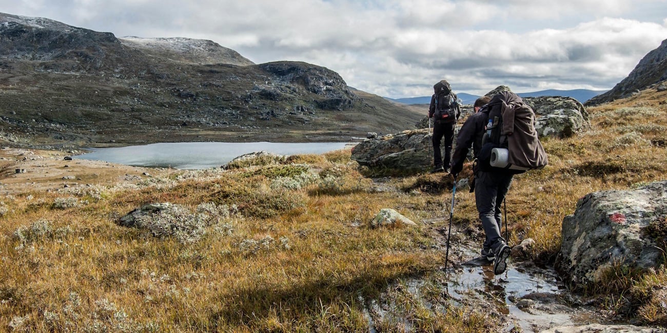 To personer som går på tur i fjellet med stor sekk