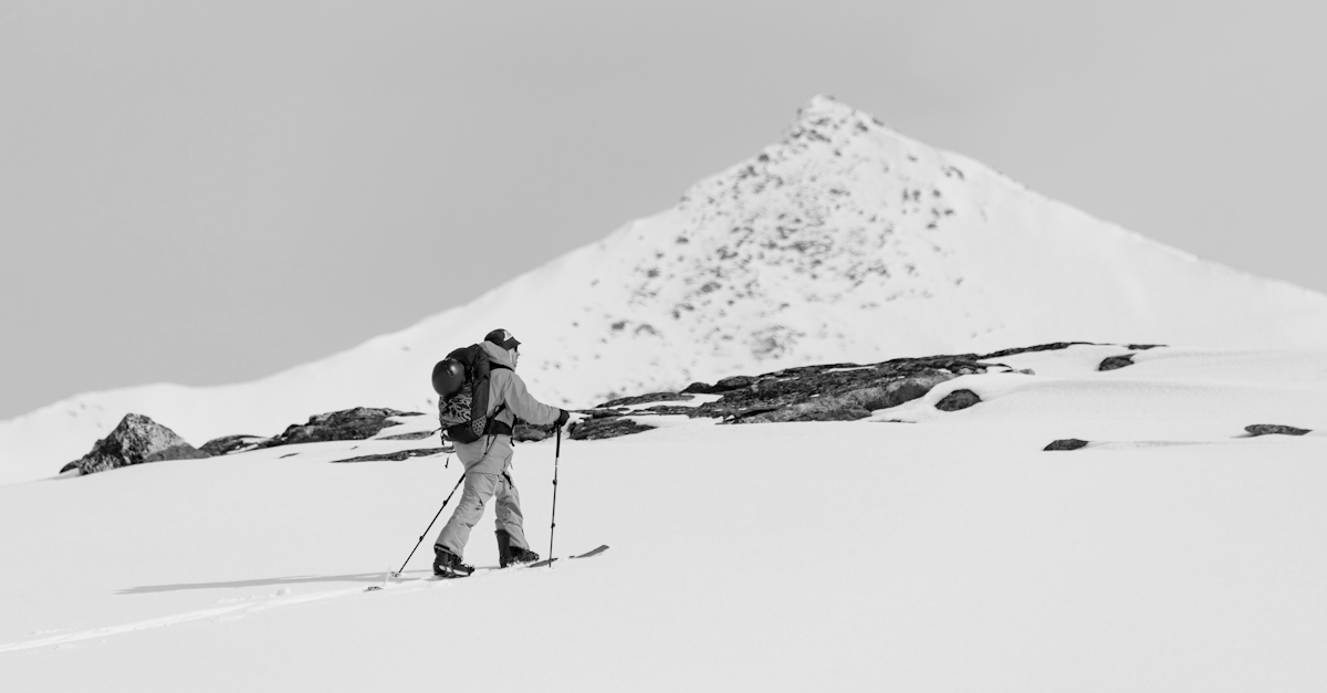 En mann som går på fjellski med et fjell i bakgrunnen
