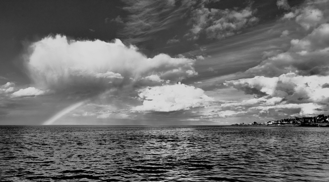 Utsikt över havet med moln och en regnbåge